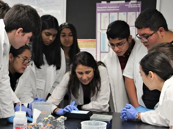 KEYS Students gathered around Mentor demonstrating experiment