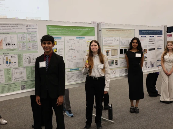 A group of interns stand in front of their posters
