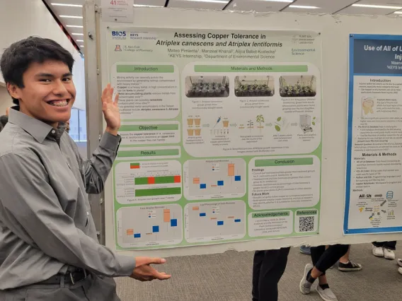 Student excitedly shows off his research poster