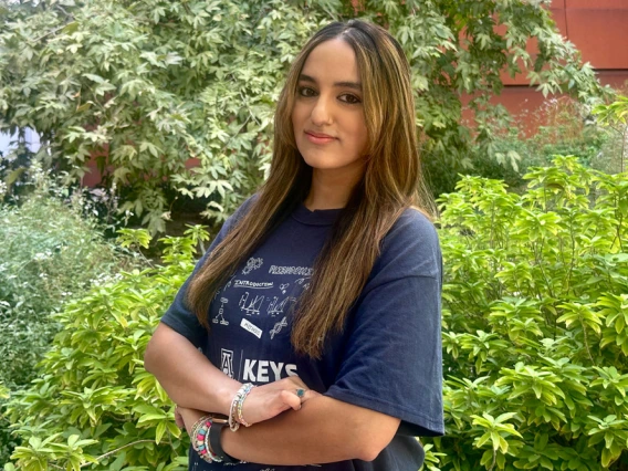 Young person standing confidently with their arms crossed