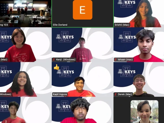 A screenshot of a virtual meeting with multiple participants, featuring individual video feeds of each person. Each participant is overlayed with their name and device type. The 'KEYS' logo is visible on some screens, and various room settings are shown in the backgrounds.