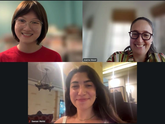 A screenshot of a video call featuring three individuals smiling. The top row shows one person in a red shirt and person in a patterned shirt with the name Joanna Masel on the right. The bottom row is a smiling person with the name Sawsan Wehbi.