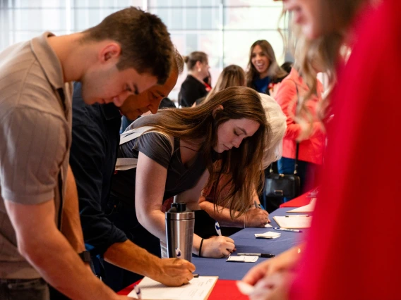 Group of individuals signing up at a registration table