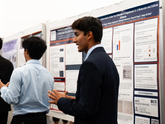 Attendees at a scientific conference discussing and reviewing poster presentations.
