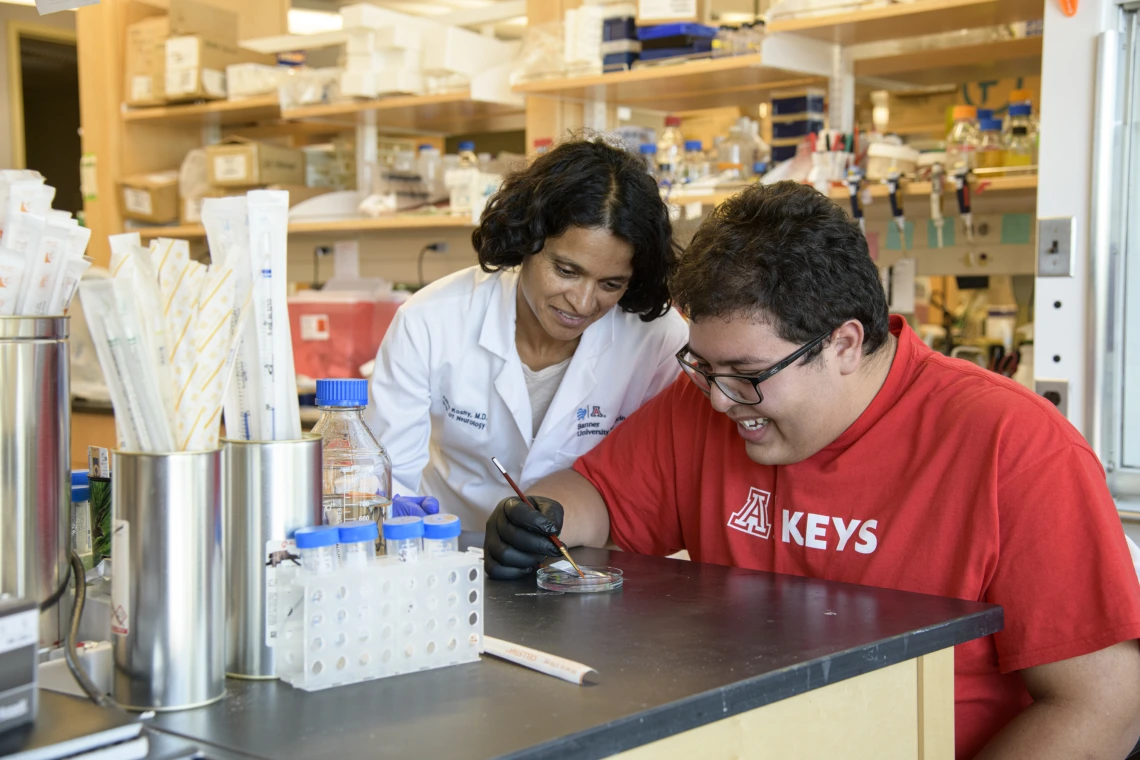 High school student working in a lab with a researcher