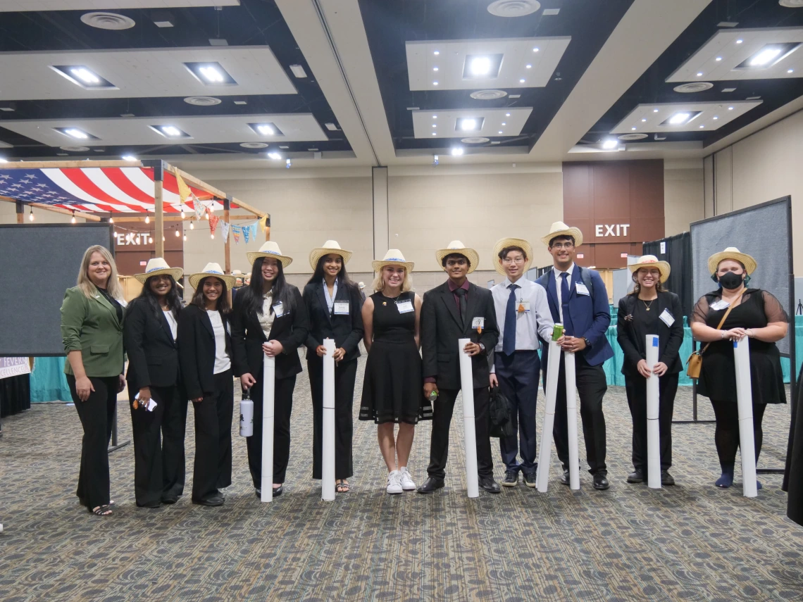 Group of young people wearing cowboy hats and posing with their posters