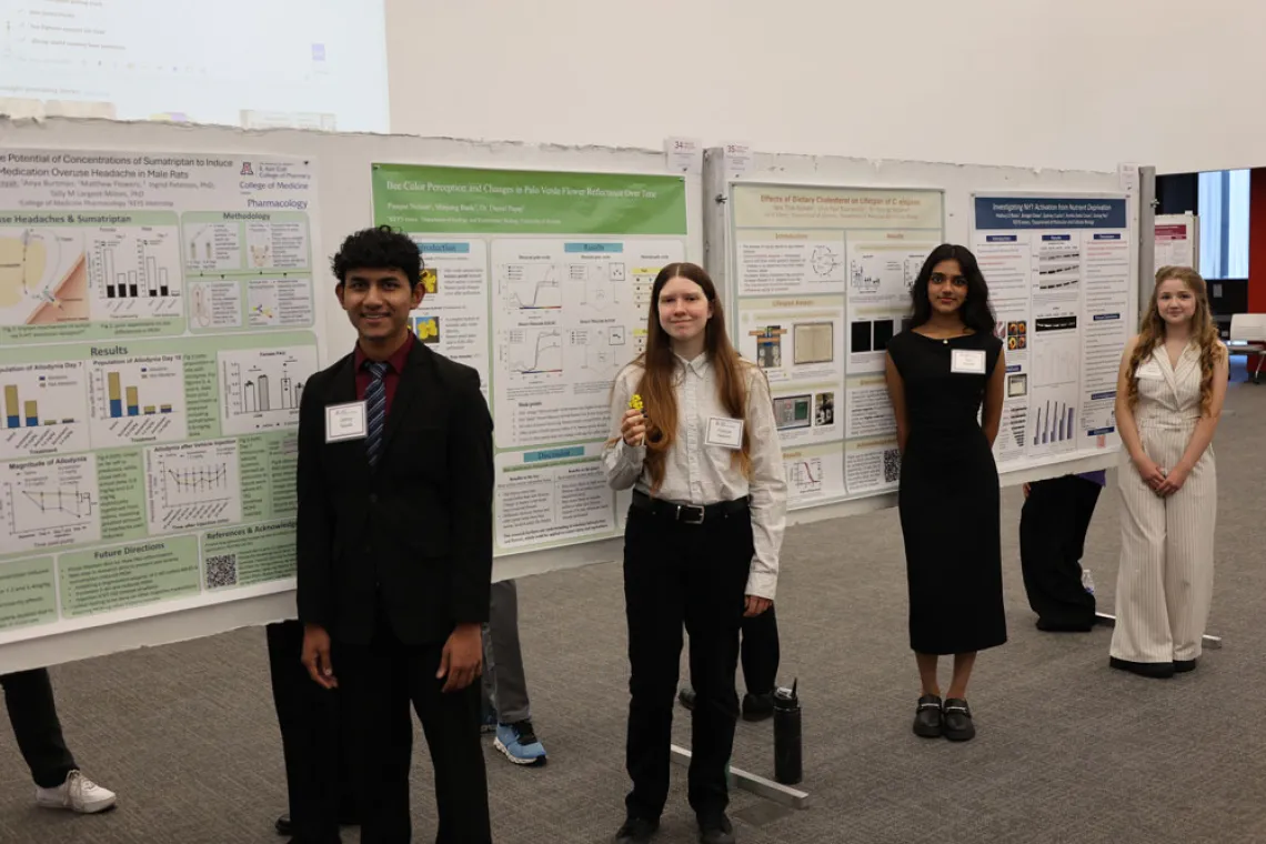 A group of interns stand in front of their posters