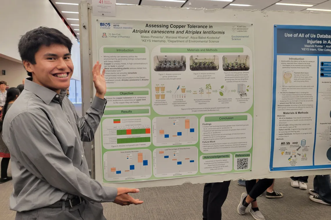 Student excitedly shows off his research poster