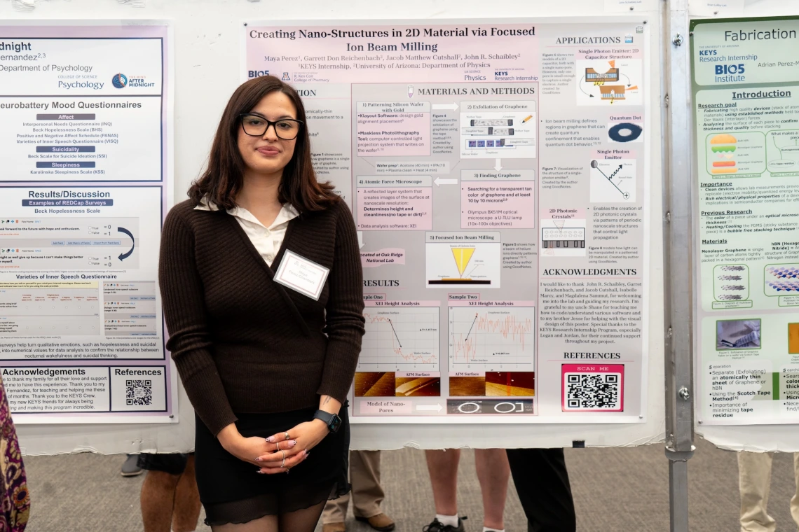 Person standing in front of a research poster presentation at a science conference. The poster includes various sections like abstract, introduction, materials and methods, results, and references, along with graphical data and illustrations.