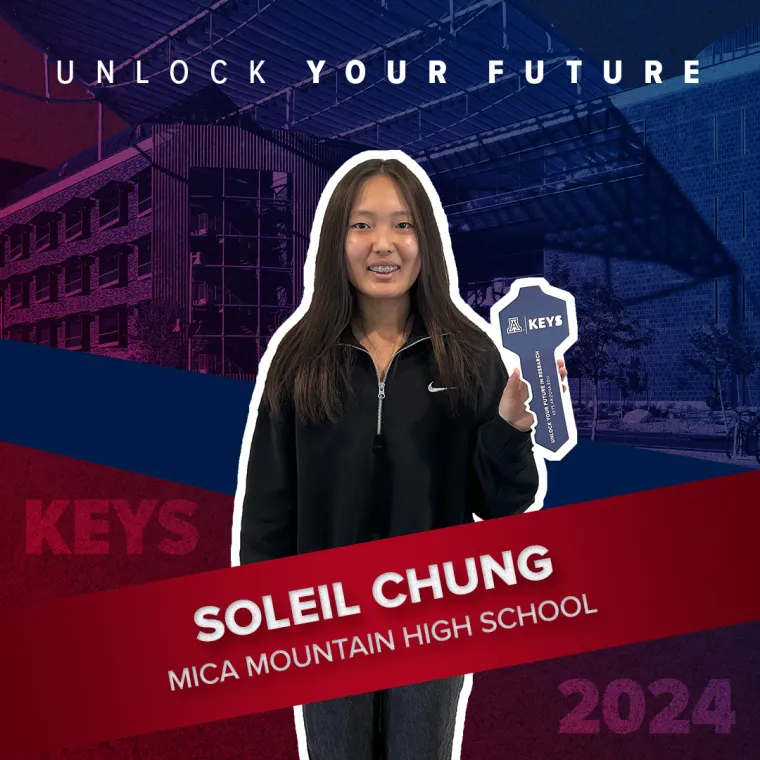 A high school student holding a paper key