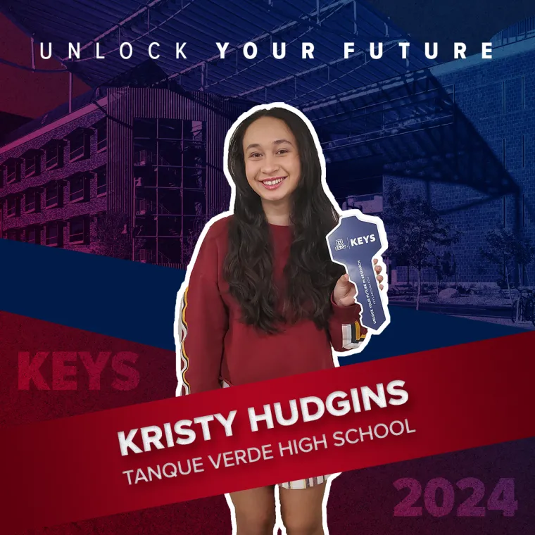 A high school student holding a paper key