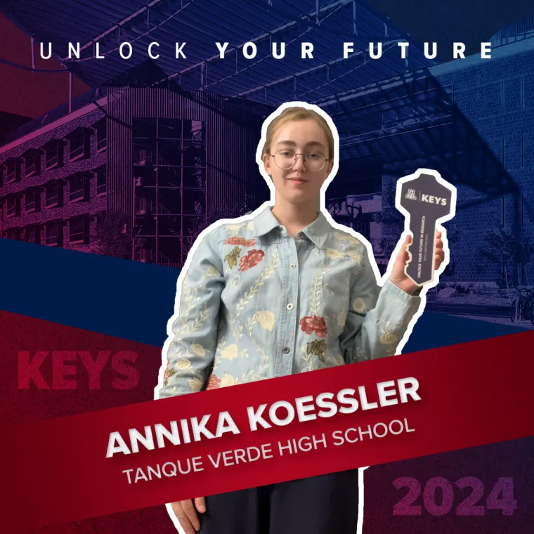 A high school student holding a paper key