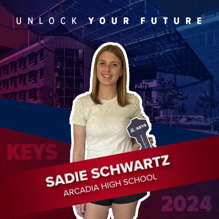 A high school student holding a paper key
