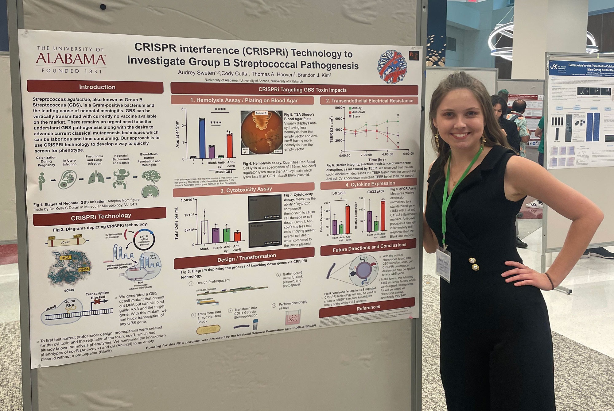 Young woman poses next to her scientific poster