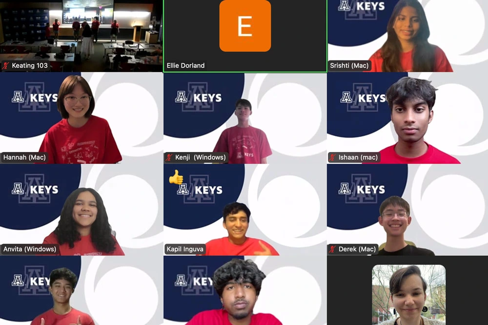 A screenshot of a virtual meeting with multiple participants, featuring individual video feeds of each person. Each participant is overlayed with their name and device type. The 'KEYS' logo is visible on some screens, and various room settings are shown in the backgrounds.