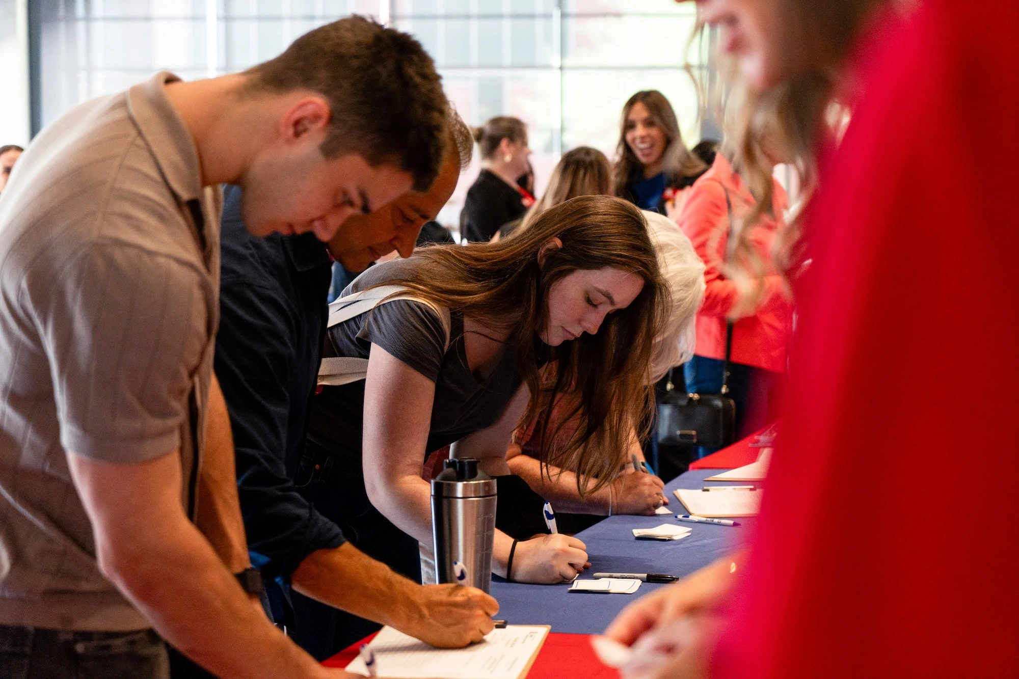Group of individuals signing up at a registration table