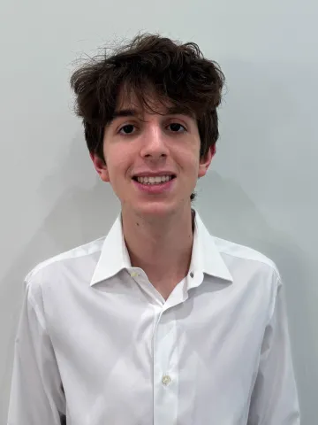 Portrait of a smiling person in a white shirt against a light-colored background.