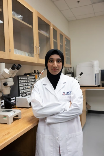 student posing in a lab coat
