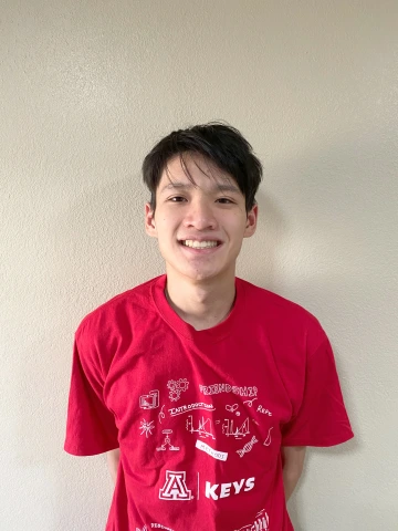 KEYS Intern with a white background wearing a red KEYS shirt.