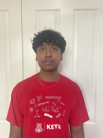 KEYS intern wearing red KEYS shirt, with a white background