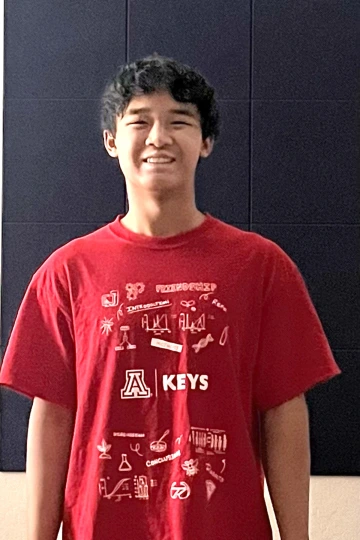 KEYS Intern wearing red shirt, with a blue background.